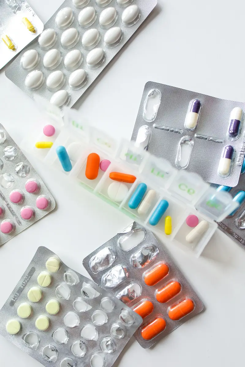 Weekly pill organizer and blister packs with medications sorted by day
